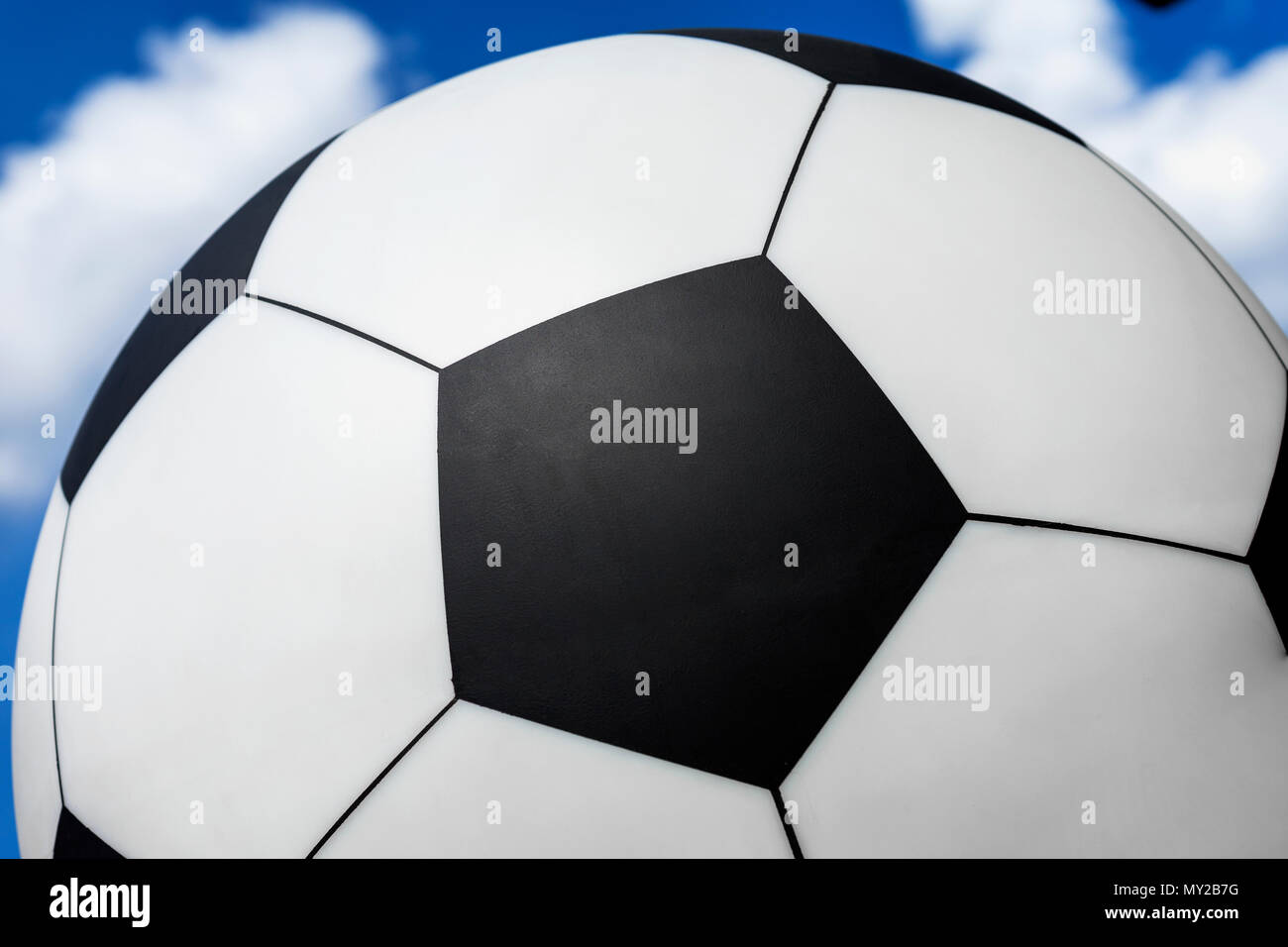 Balón de fútbol contra el cielo azul con nubes blancas, la textura, el Fondo para el deporte Foto de stock