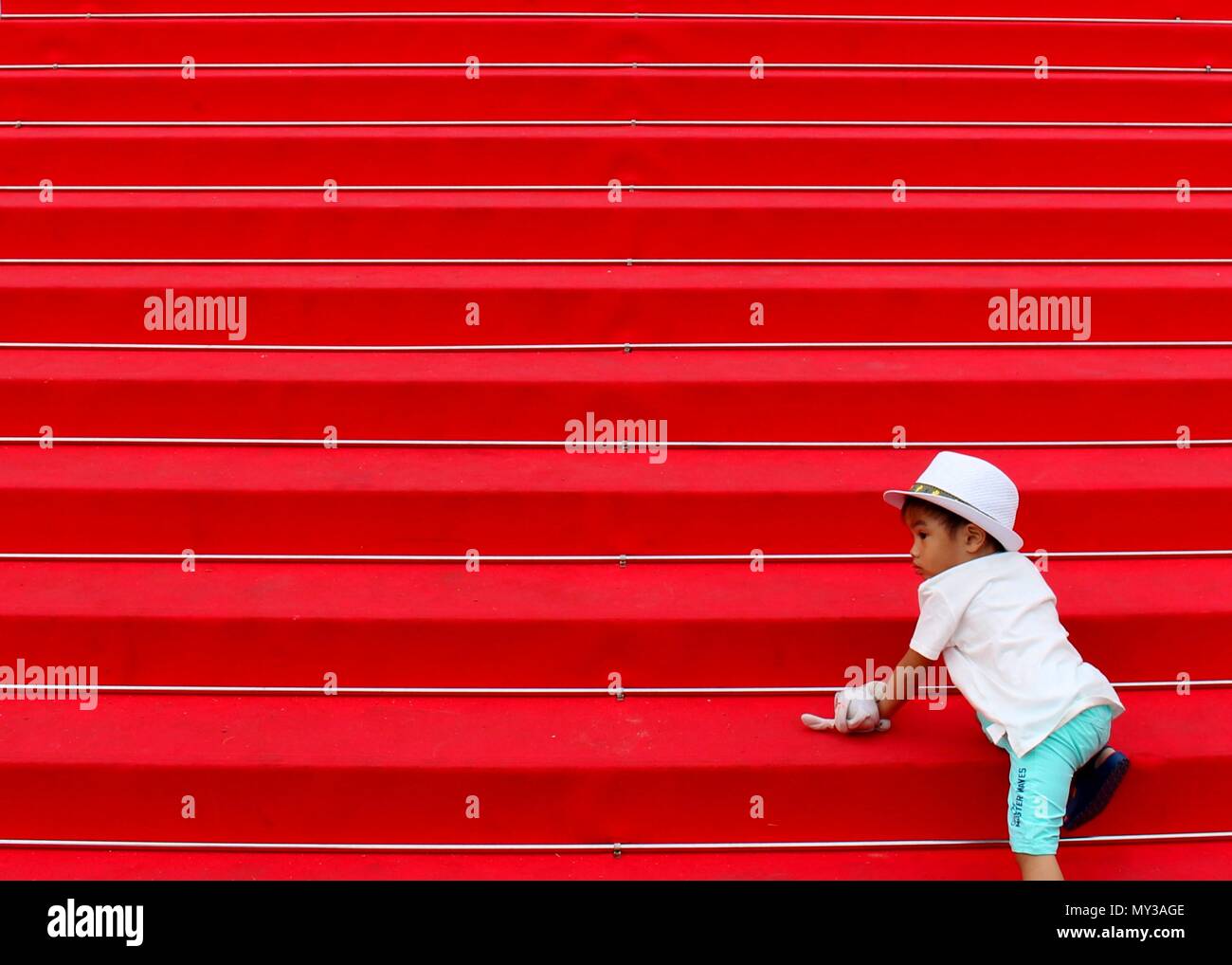 Un niño acends la famosa alfombra roja medidas conducentes al Palais des Festivals et des Congrès. Foto de stock