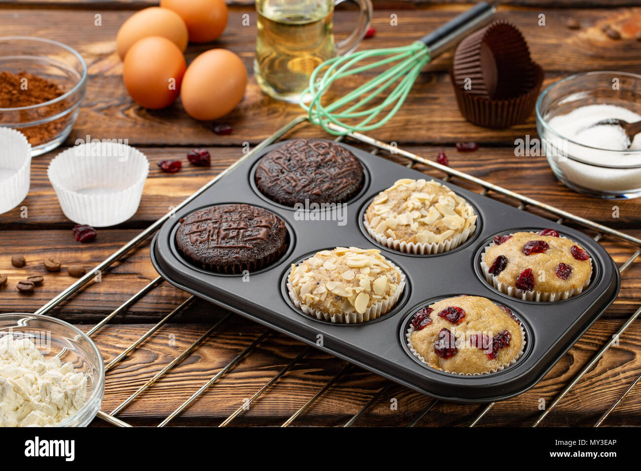 En bakeware diferentes Muffins o magdalenas pan sobre fondo de madera  broun. Muffin receta básica. Muffins caseros para el desayuno o el postre.  Ingredientes Fotografía de stock - Alamy