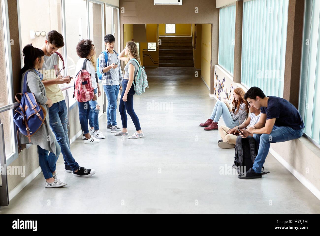 Los estudiantes matando el tiempo en el corredor entre las clases Foto de stock