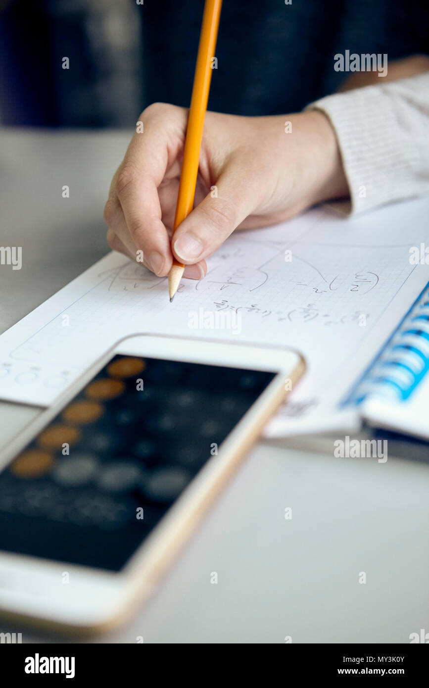 El estudiante trabaja sobre la tarea de matemáticas, recortadas Foto de stock