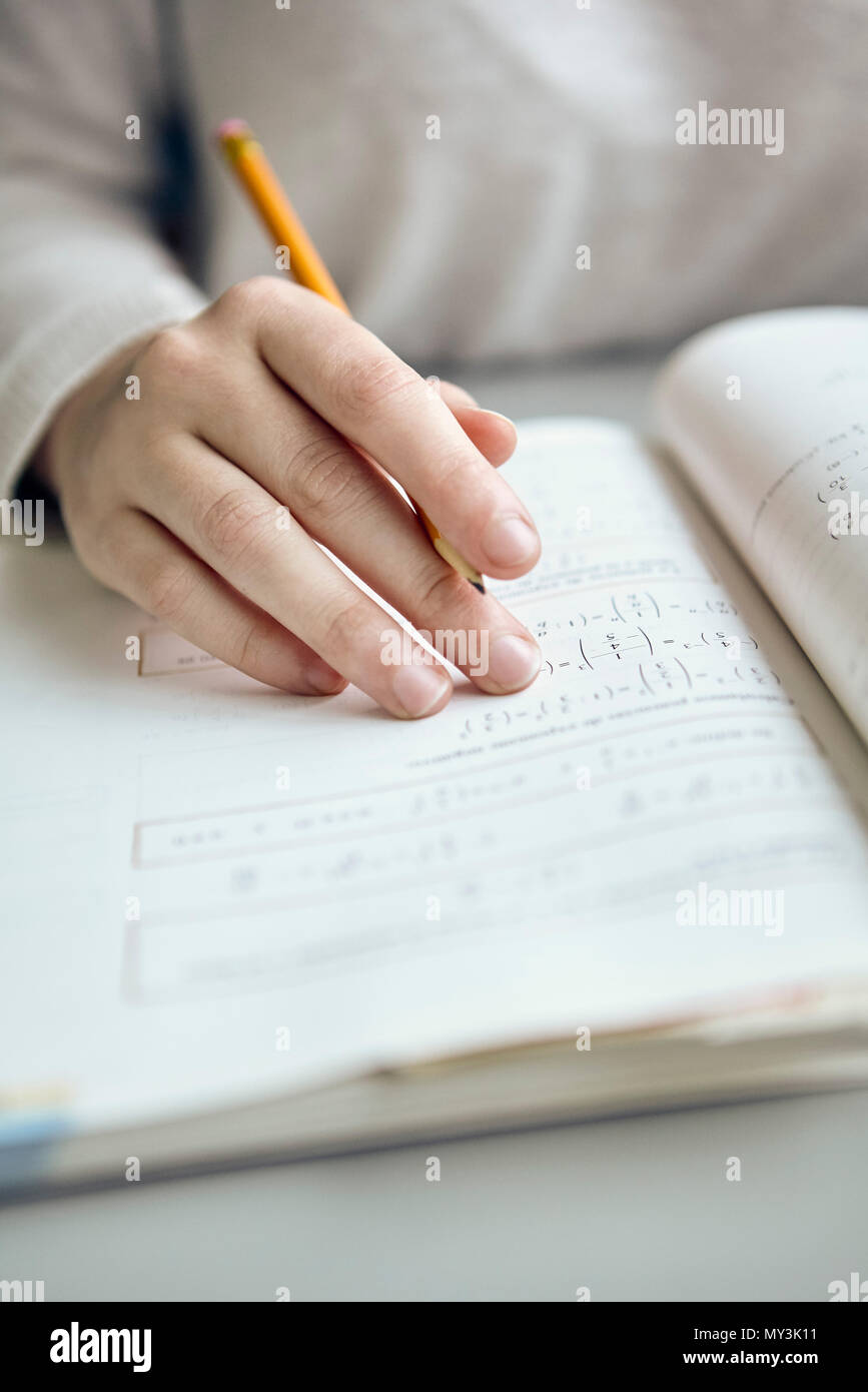 El estudiante trabaja sobre la tarea de matemáticas, recortadas Foto de stock