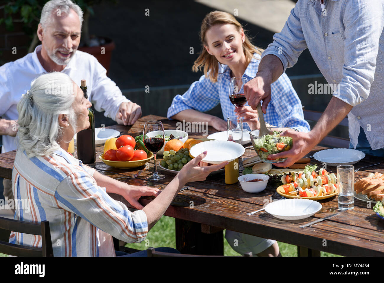 Familia feliz de tener dos generaciones juntas de picnic al aire libre Foto de stock