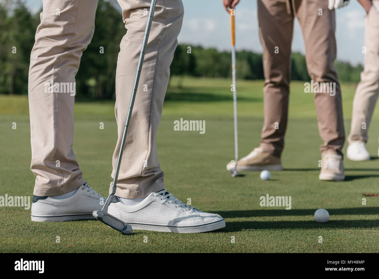 Captura recortada de jugadores profesionales de golf preparándose para la filmación de una bola Foto de stock