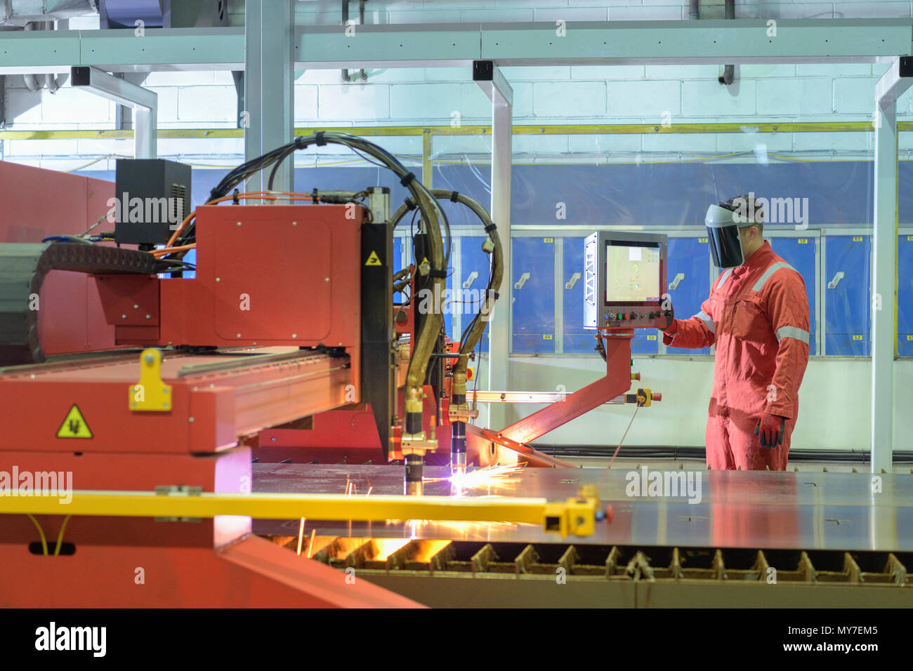 Trabajador cortador por plasma de funcionamiento en fábrica de remolque Foto de stock