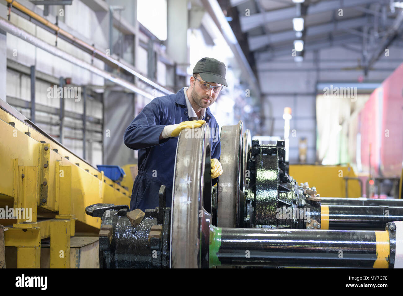 Ingeniero de inspeccionar el desgaste de las ruedas de la locomotora en tren fábrica de ingeniería Foto de stock