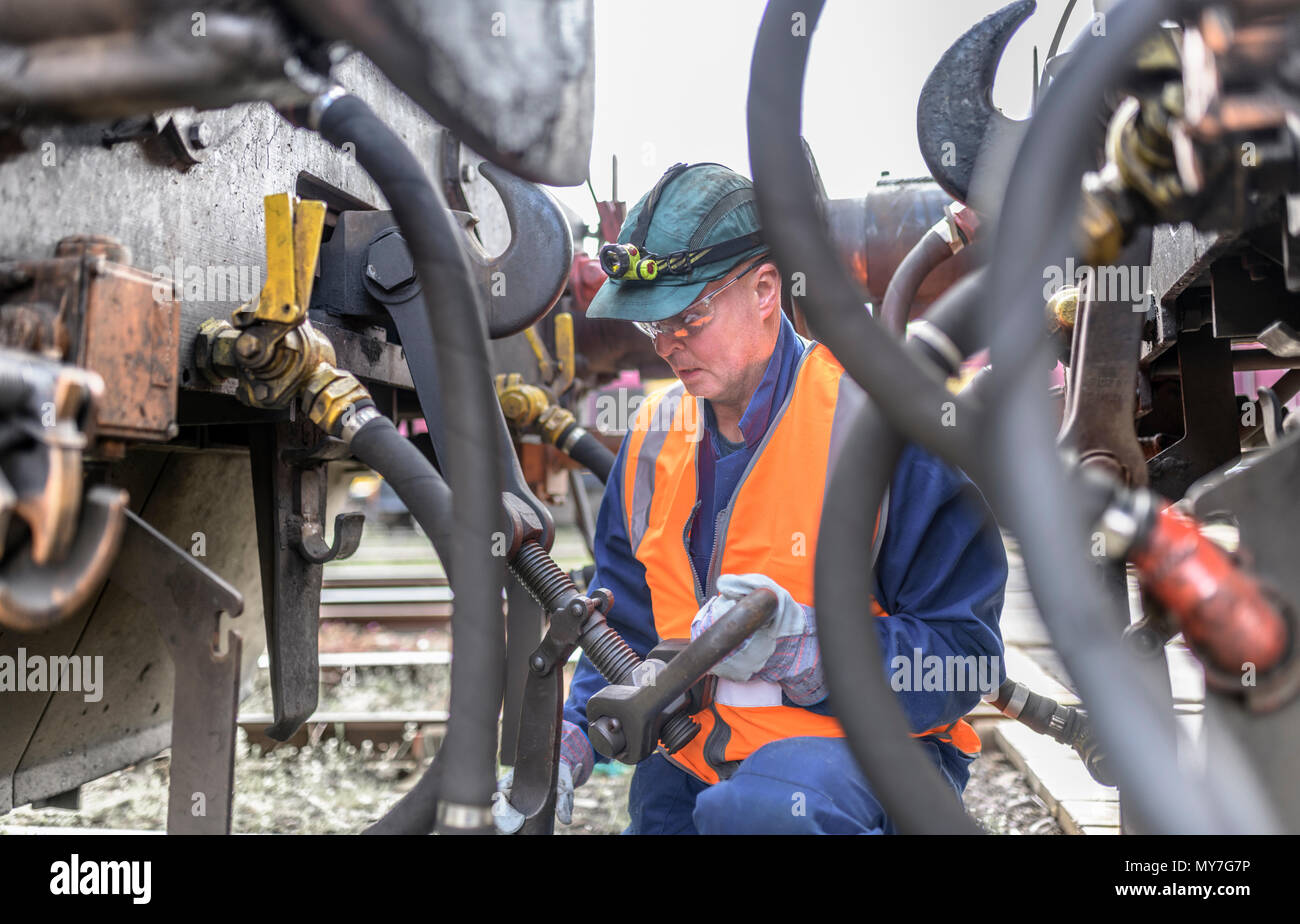Ingeniero de enganchar una locomotora a otro tren en fábrica de ingeniería Foto de stock