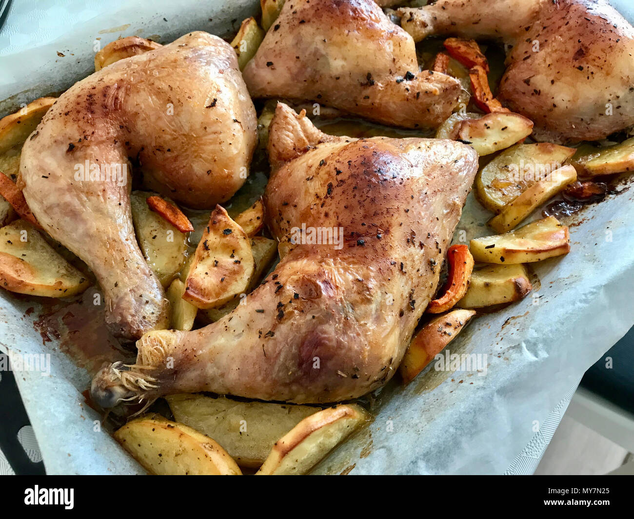 Piernas de pollo asado condimentado caseros con patatas en la bandeja del  horno. Los alimentos orgánicos Fotografía de stock - Alamy