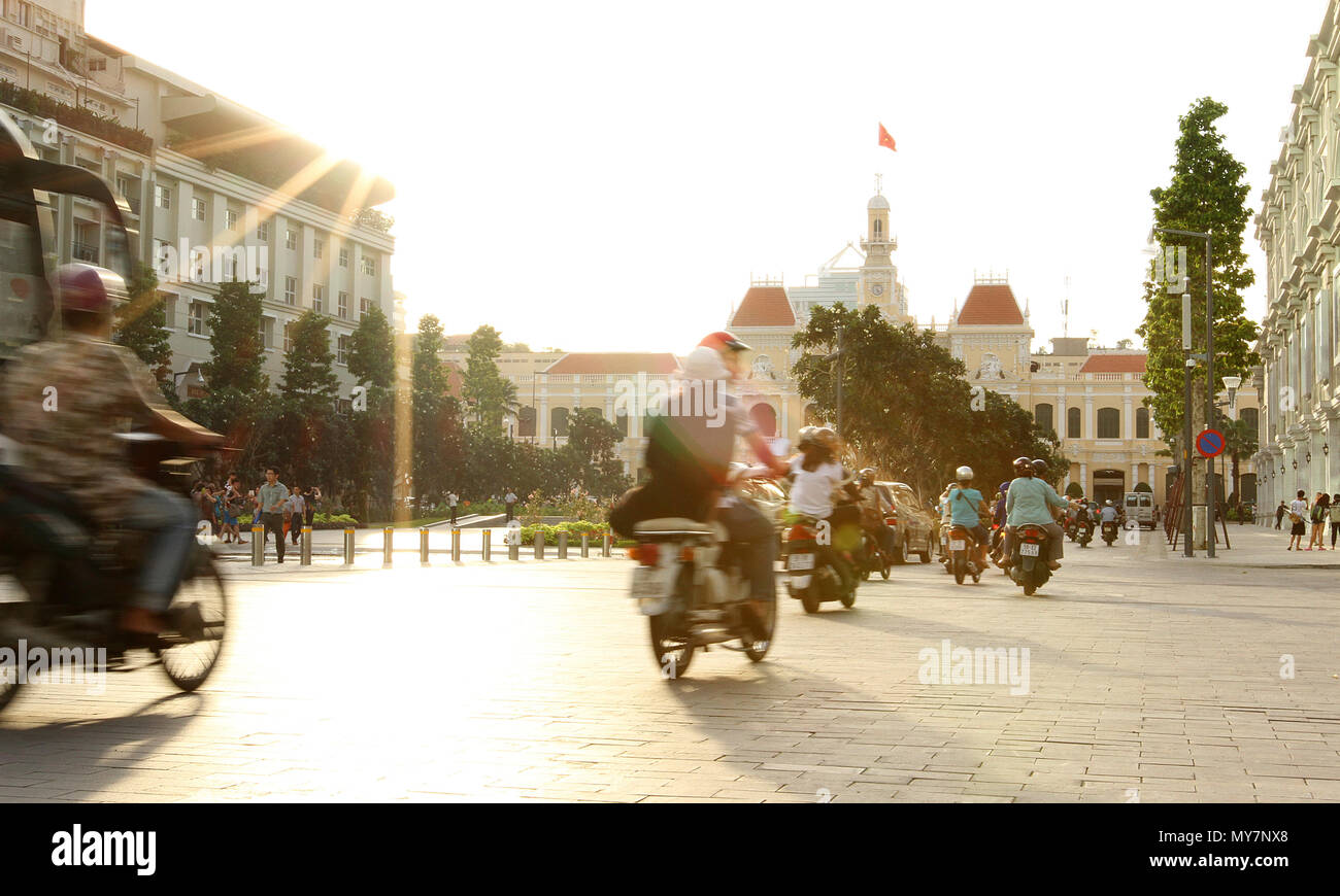 Vistas a la ciudad de Ho Chi Minh city town hall en Sunset con motocicletas en movimiento y bandera vietnamita. Guía turística vacaciones viajes concepto. Vietnam Foto de stock