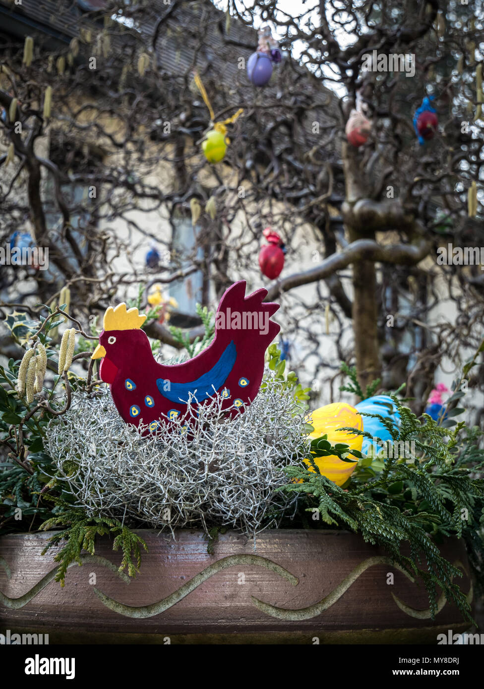Adornos de Pascua (pollo y huevos) en un paisaje de jardín (Alemania). Foto de stock