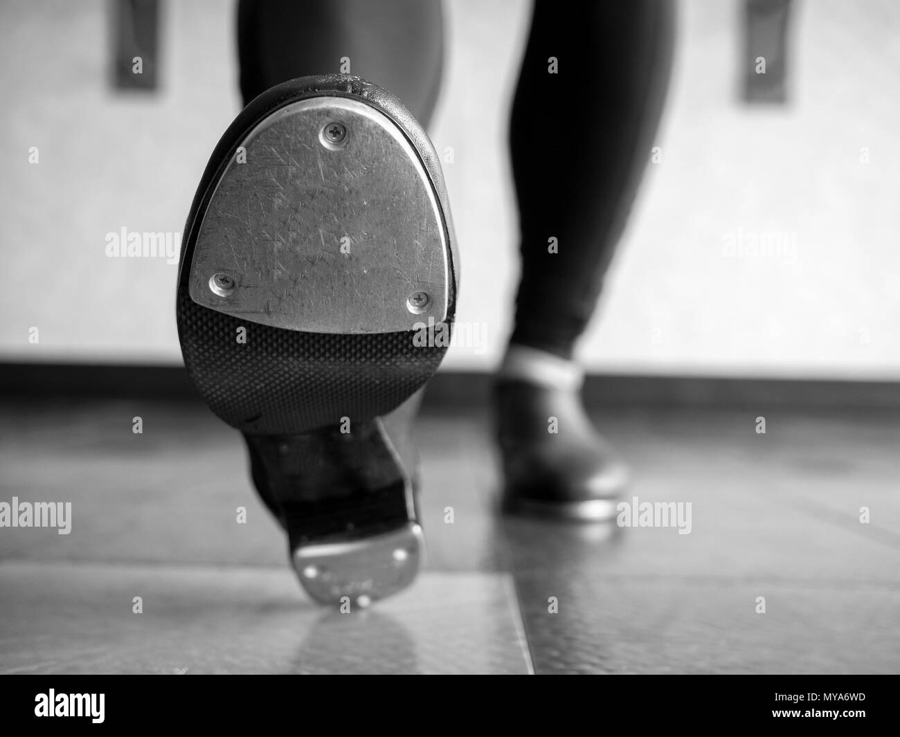 Versión en blanco y negro de la convergencia en el talón toca los zapatos en la clase de baile Foto de stock