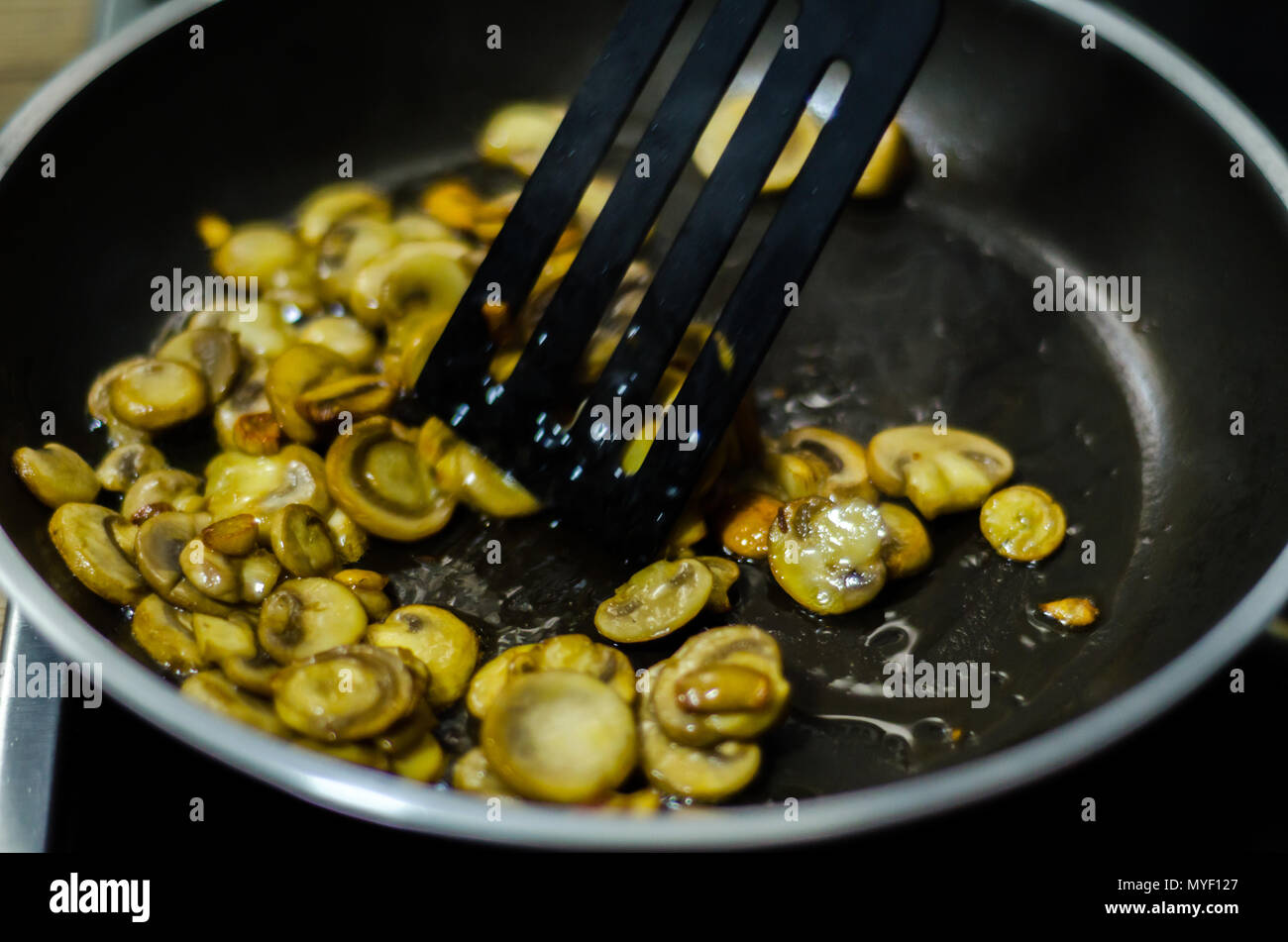 Champiñones rebanados fritos en mantequilla en una sartén, plato  vegetariano, refrigerio saludable Fotografía de stock - Alamy