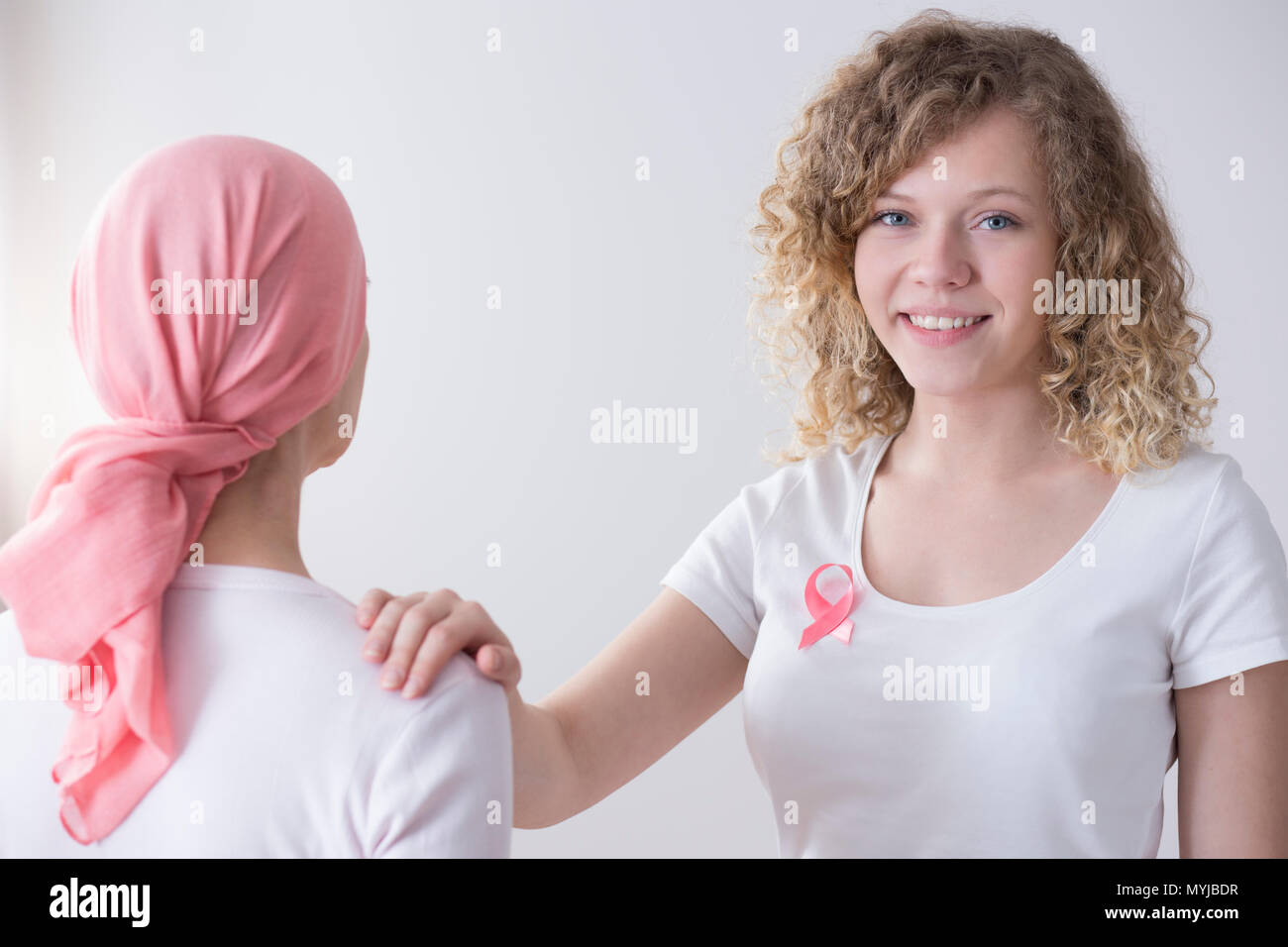 Mujer sonriente con Pink Ribbon apoyando al enfermo con cáncer Foto de stock