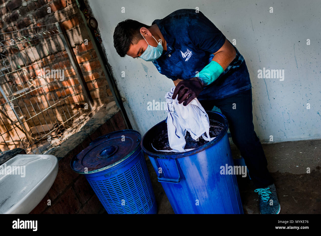 Un textil salvadoreño dyer sumerge un paño envuelto en el baño colorante  índigo se mantienen en un taller de confección artesanal en Santiago  Nonualco, El Salvador Fotografía de stock - Alamy