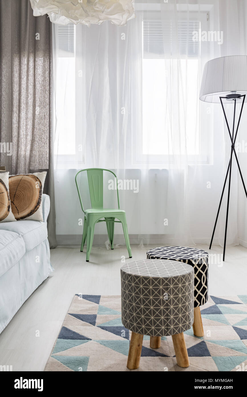 Habitación con los taburetes tapizados de luz, patrón de alfombra, lámpara de piso Foto de stock