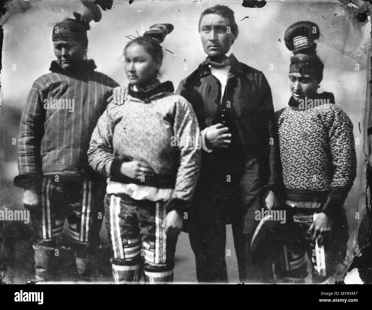 . Inglés: un grupo Inuit en los Inuit y ropas europeas. Un hombre Inuit vestida con ropas europeas con tres mujeres Inuit en ropa tradicional. La prenda superior de la mujer en el derecho puede ser tejida de lana (como los usados por el funcionario danés y sus hijos en G4263) y pueden representar una fusión entre los Inuit y ropa nórdica. El álbum Inglefield celebrada por la Real Archivos registros observó que la gente en la fotografía son (l-r), madre, hija, novia, y la cuñada. Un grupo Inuit en Inuit Eurpoean y ropa. . 8-17 de junio de 1854. El capitán Edward Augustus Inglefield 351 Un Inu Foto de stock