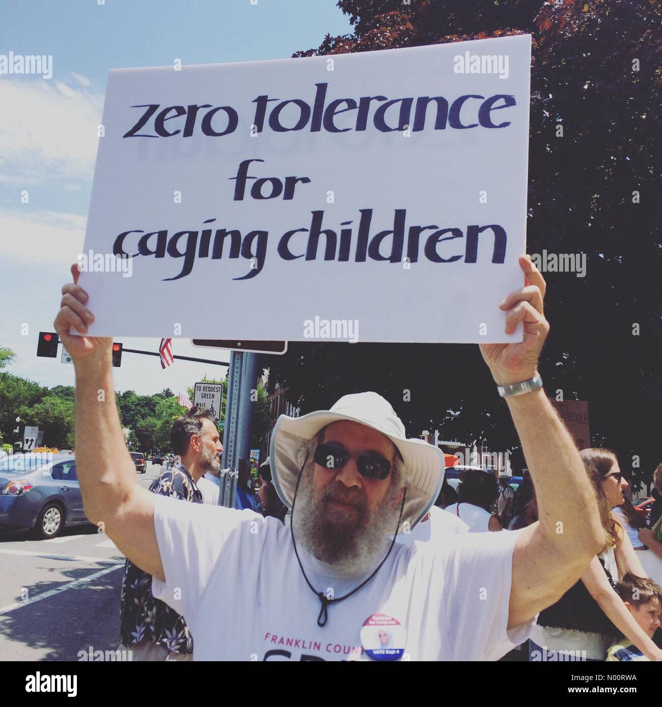El 30 de junio, 2018. Greenfield, Massachusetts, Estados Unidos. Familias pertenecen juntos en un rally, un hombre sostiene un cartel que dice "tolerancia cero para jaulas para niños". Foto de stock