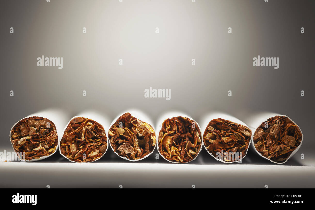 Composición conceptual acerca de fumar cigarros, el consumo de tabaco como hábito insalubre. Foto de stock