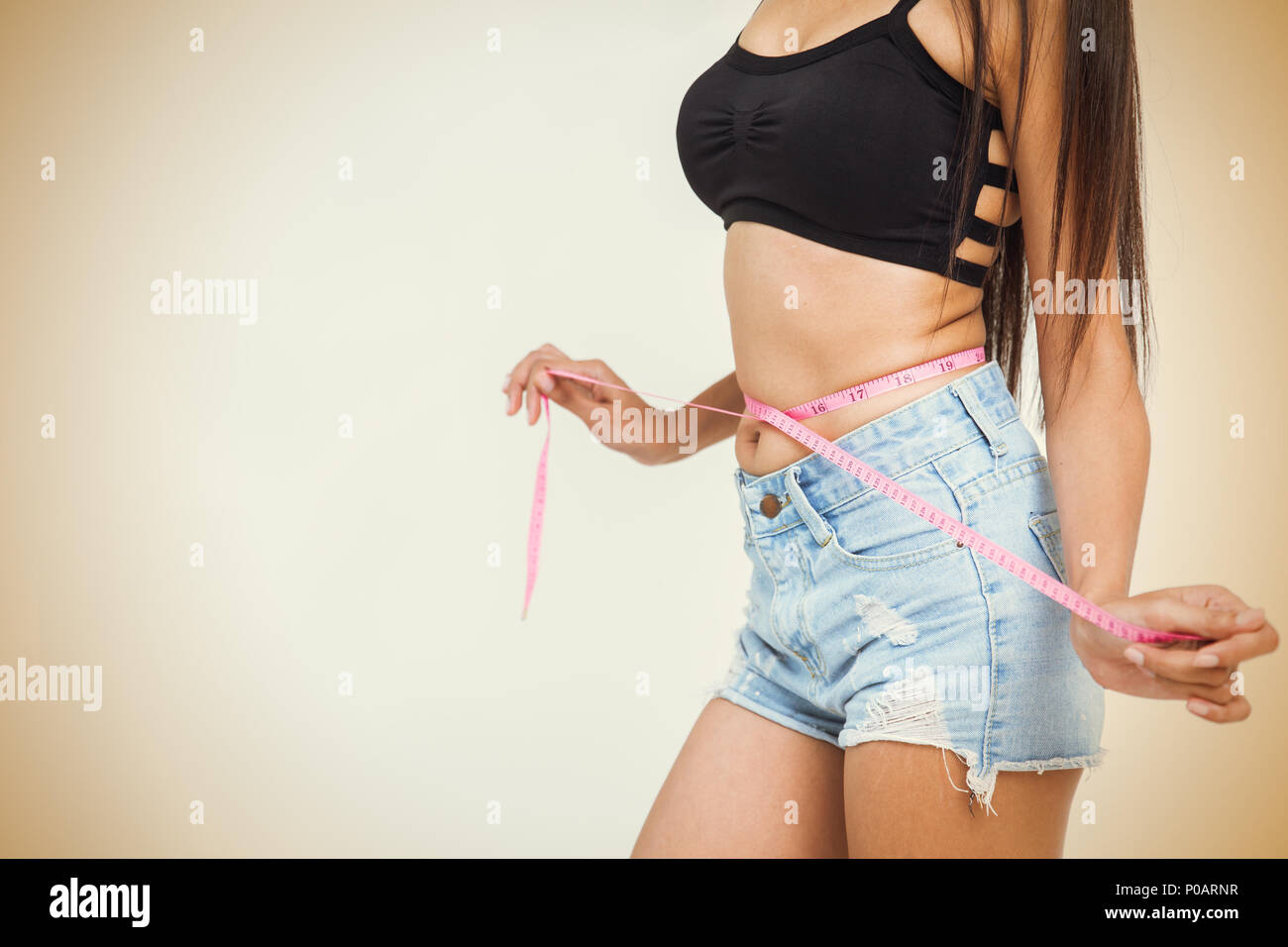 medir la cintura por la cinta. mujer joven con cuerpo delgado y ropa de  yoga está en casa 8237590 Foto de stock en Vecteezy