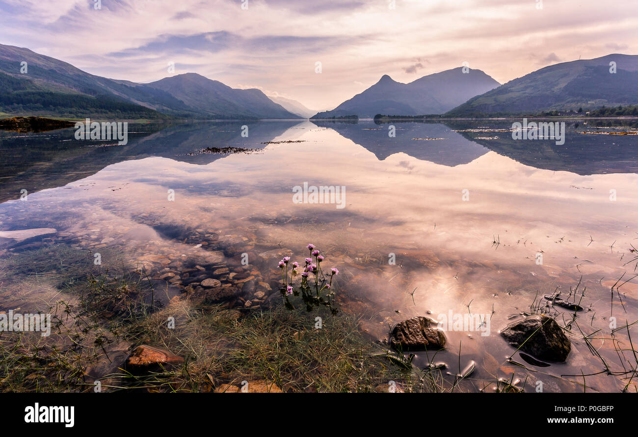 Tranquilo Loch Leven reflexiones temprano en la mañana del día de la primavera clara , las Tierras Altas de Escocia, Scotland, Reino Unido Foto de stock