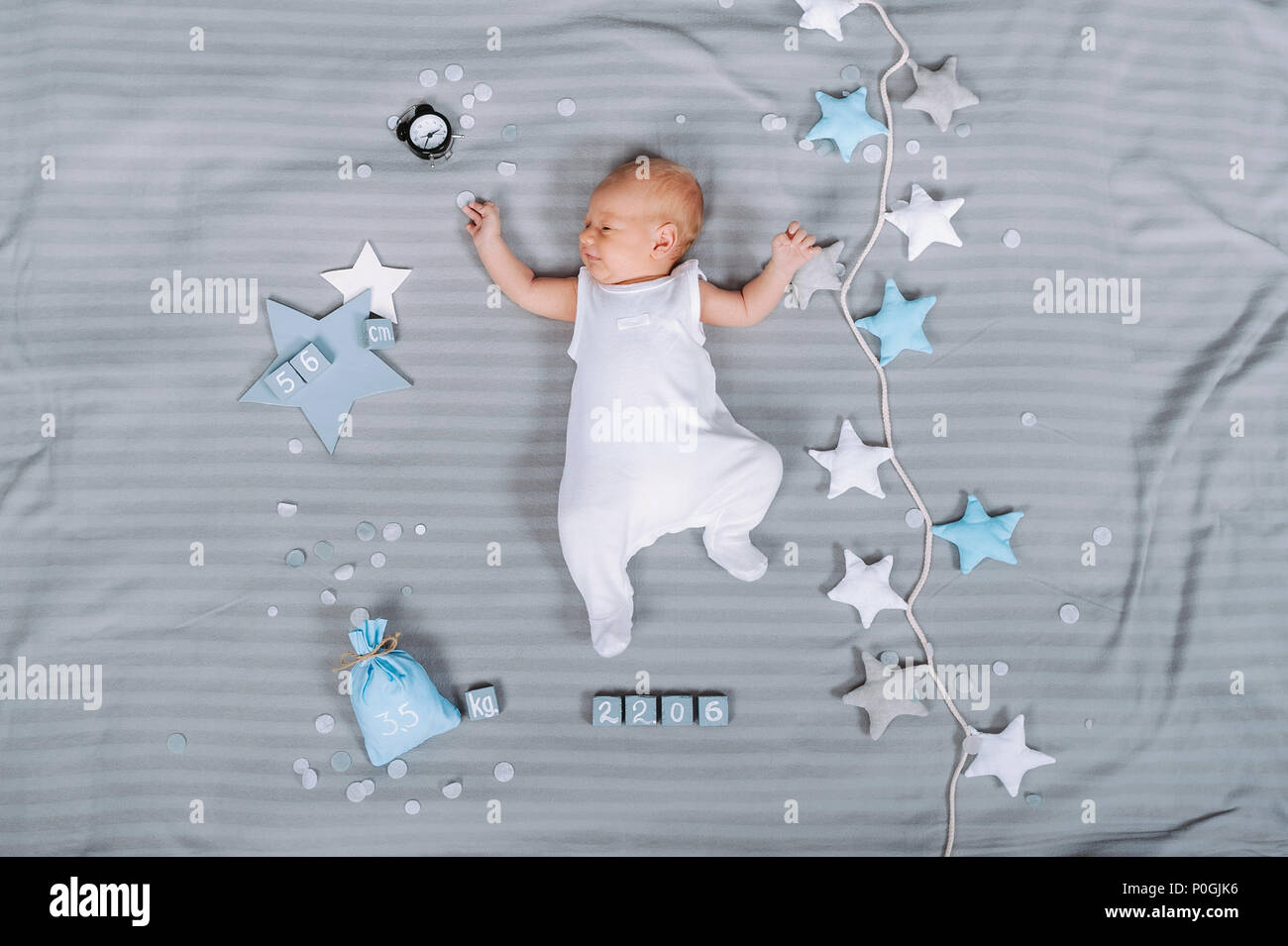 Vista aérea de la adorable bebé recién nacido en bodysuit tumbado en la  cama con adornos alrededor Fotografía de stock - Alamy