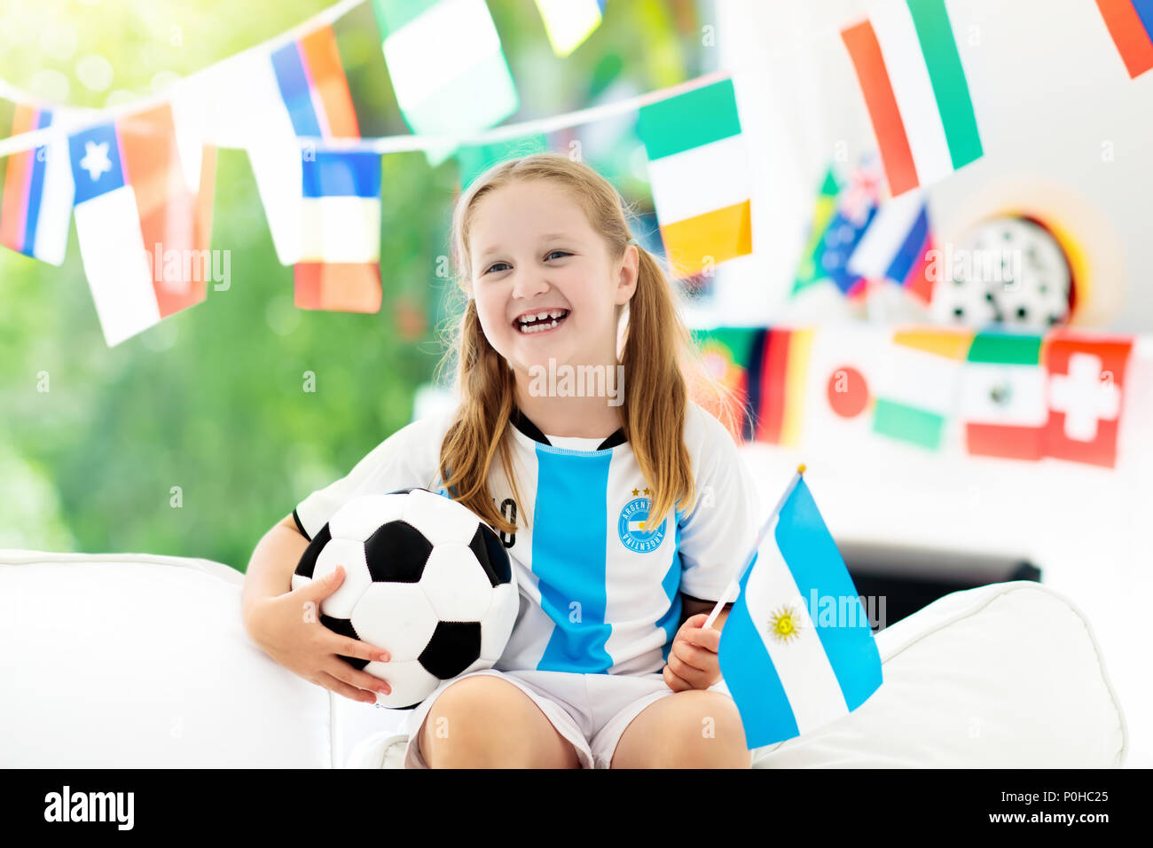 Niño viendo partido de fútbol en la televisión. Chica en Argentina jersey  viendo partido de fútbol durante el campeonato. Ventilador Kid aclamaciones  y apoyo del equipo nacional Fotografía de stock - Alamy