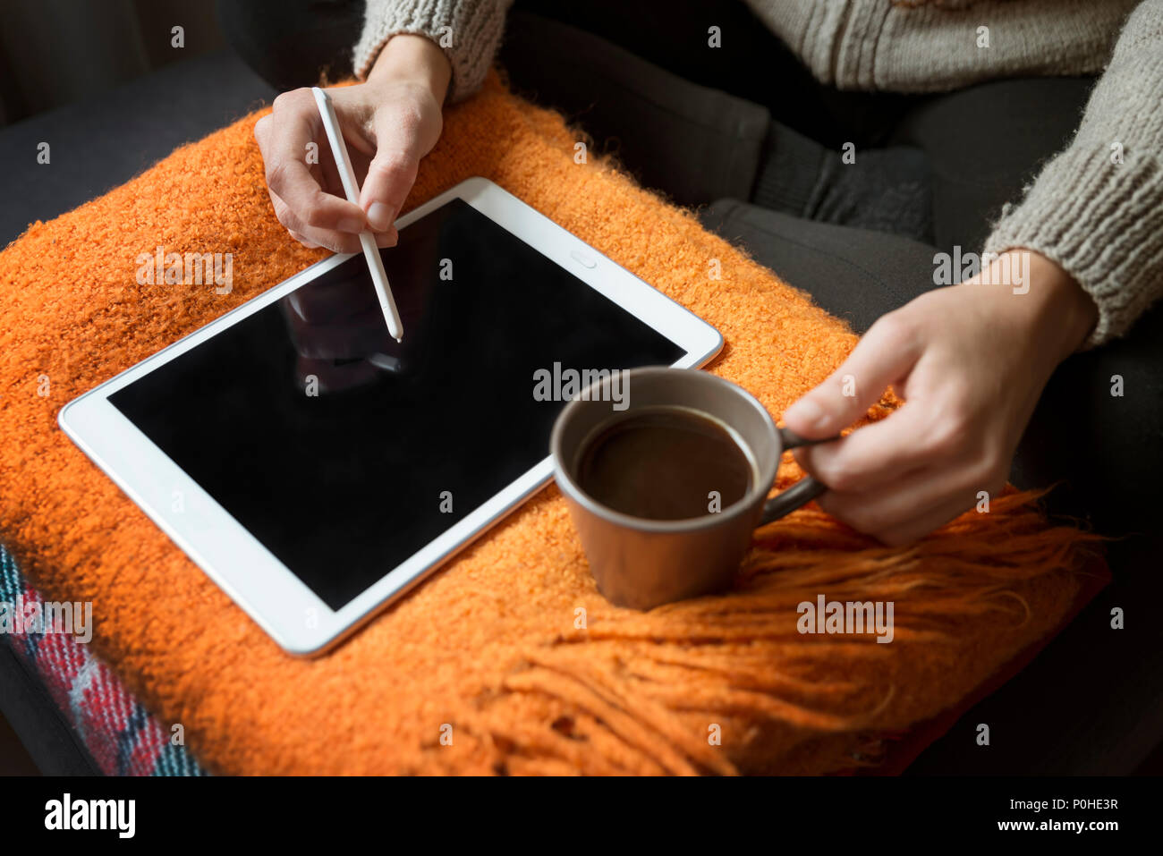 Mujer con Digital Tablet y beber café en casa Foto de stock