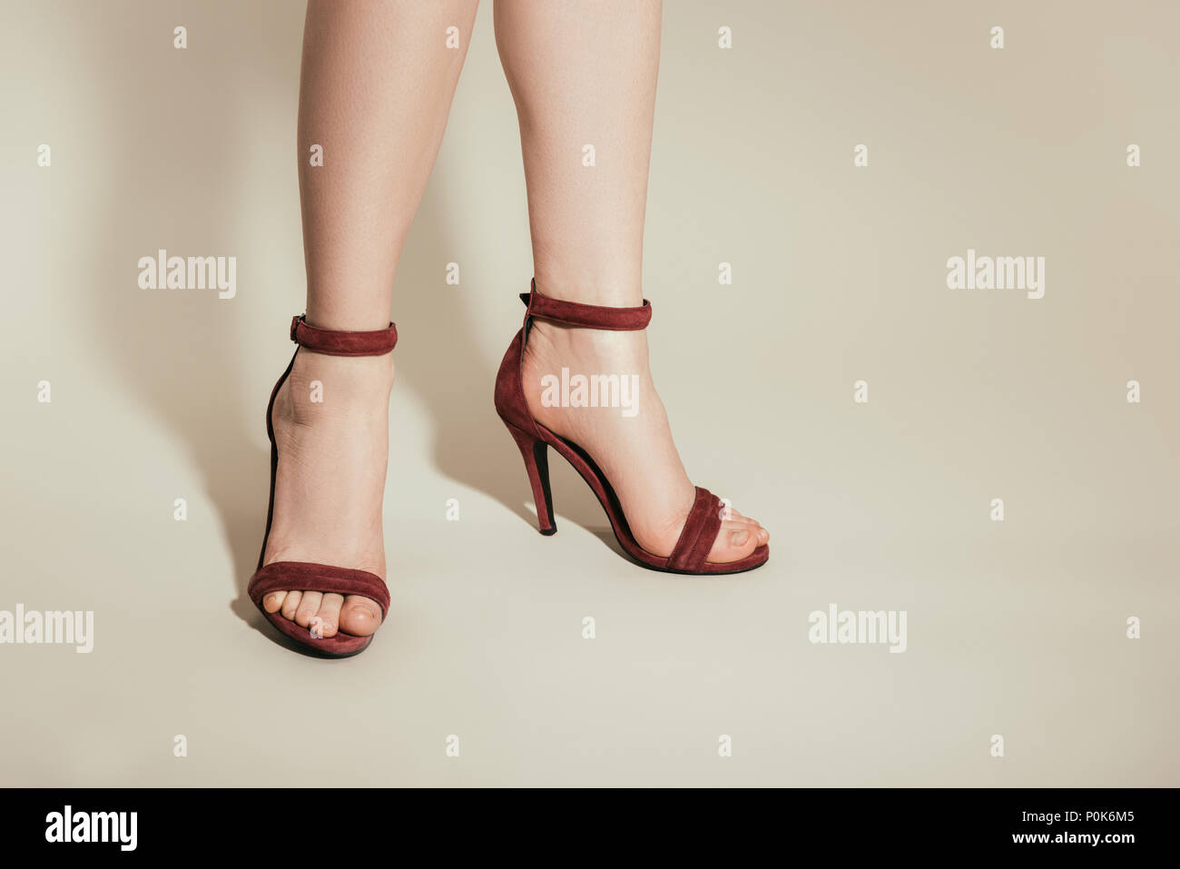 Imagen recortada de mujer pies en sandalias de tacón alto y elegante sobre  fondo blanco Fotografía de stock - Alamy