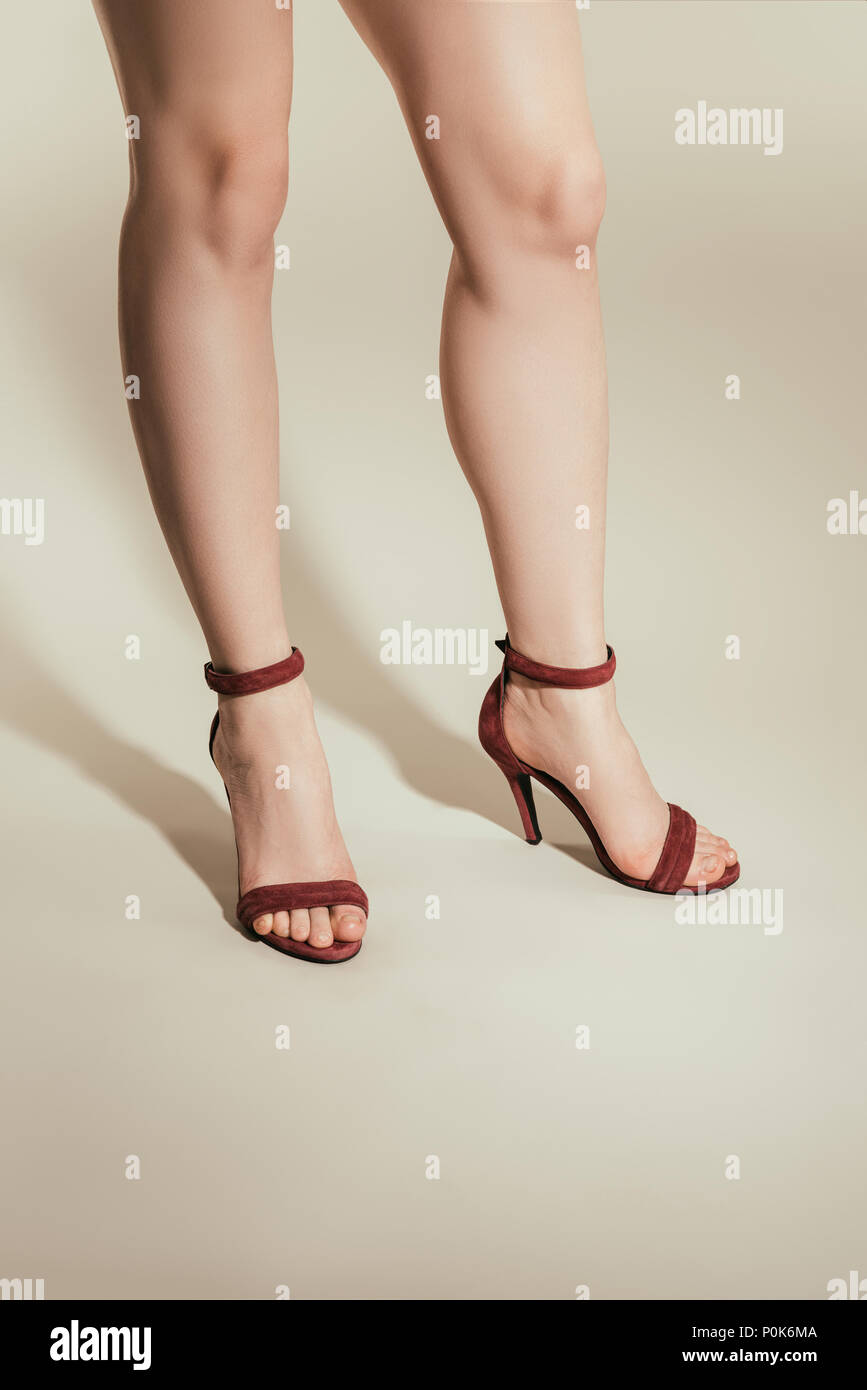 Imagen recortada de una mujer de piernas en sandalias de tacón alto sobre  fondo blanco Fotografía de stock - Alamy
