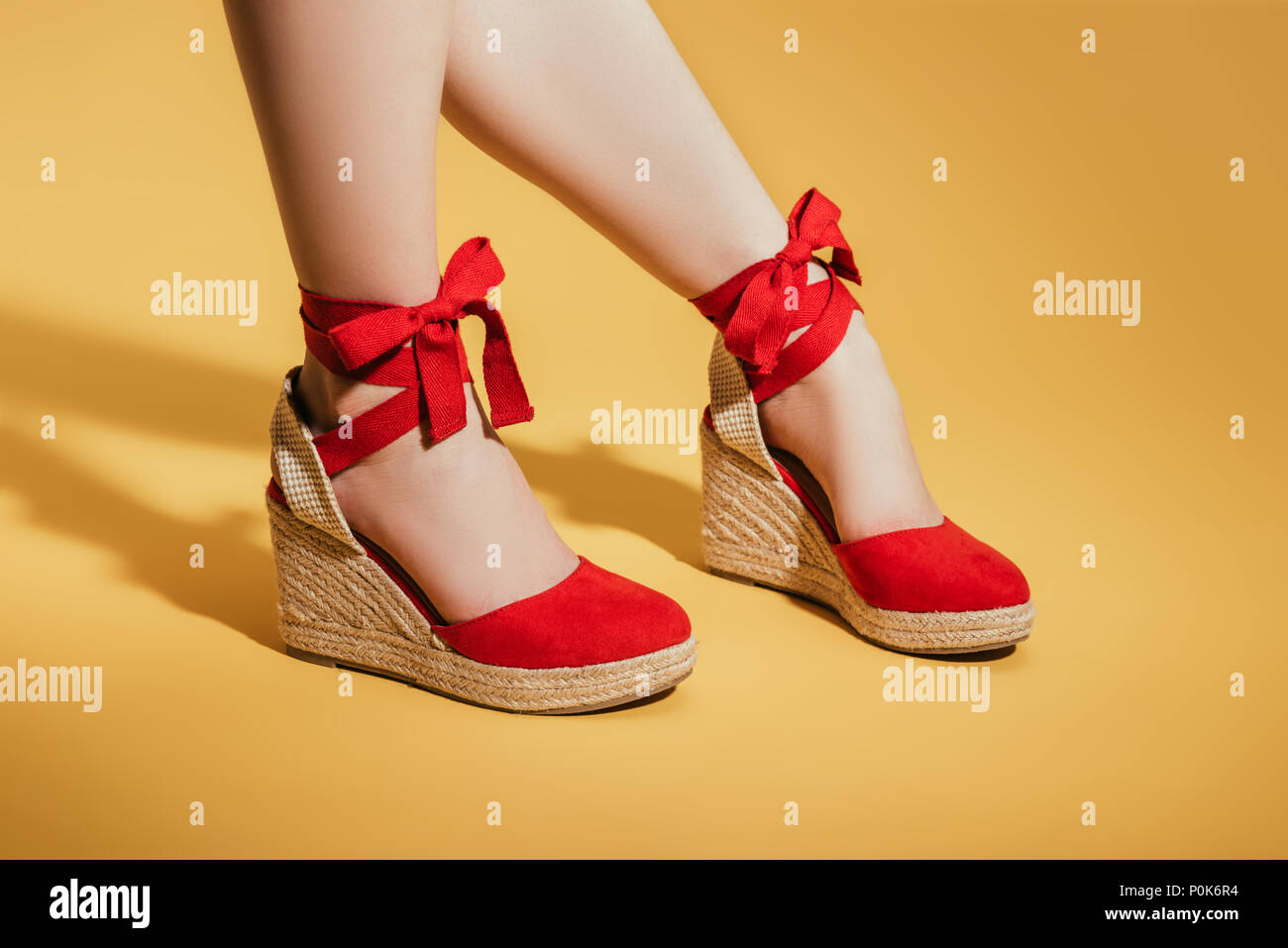 Imagen recortada de mujer pies en elegantes sandalias de plataforma sobre amarillo Fotografía de stock - Alamy
