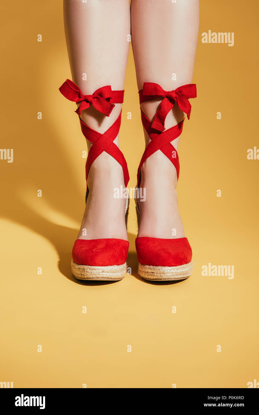 Imagen recortada de mujer pies en elegantes sandalias de plataforma sobre  fondo amarillo Fotografía de stock - Alamy