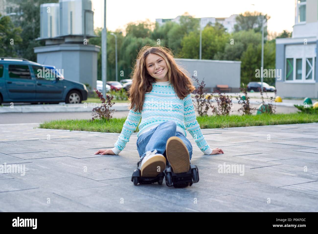 Chica adolescente en las ruedas de los rodillos, adaptado a las zapatillas  de deporte. Fondo urbano Fotografía de stock - Alamy