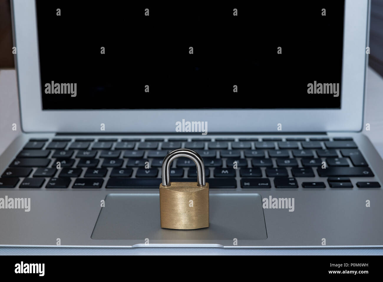 Un portátil con una cerradura en la parte delantera como un concepto de seguridad web, con copyspace Foto de stock