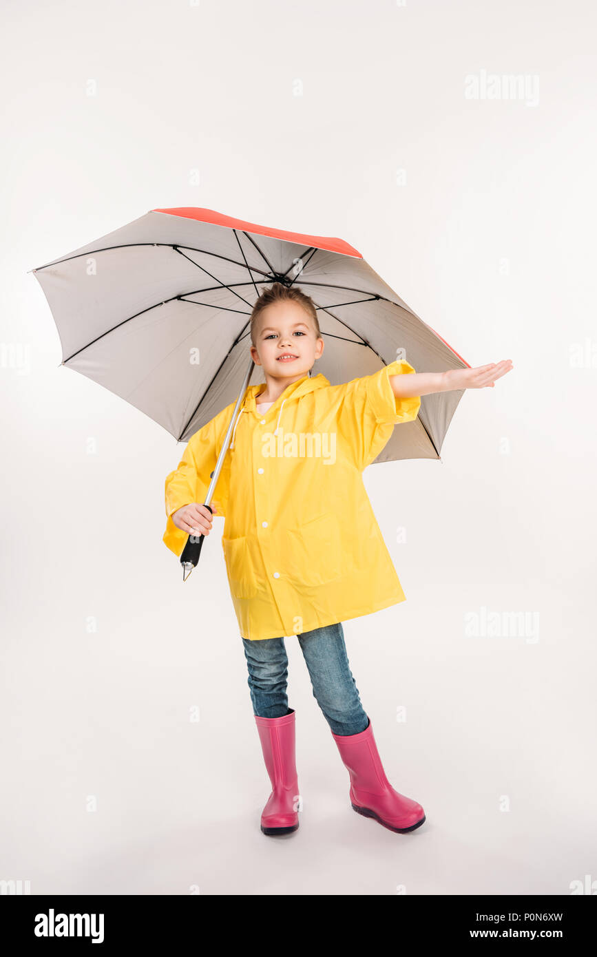 Hermosa niña en botas de caucho, impermeable amarillo con sombrilla,  aislado en blanco Fotografía de stock - Alamy