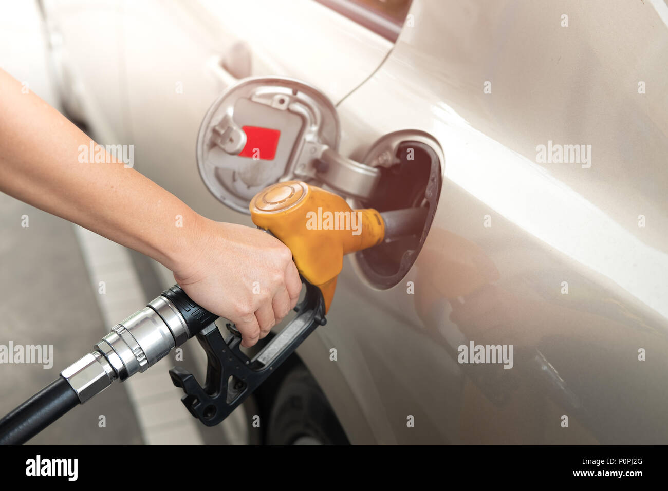 Primer plano del hombre bombea gasolina en el coche en la gasolinera.  Surtidor de combustible con una manguera en la mano Fotografía de stock -  Alamy
