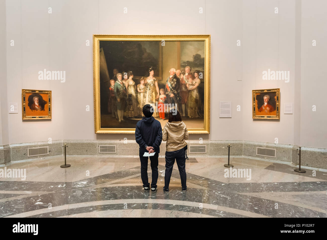 Goya pintura Prado, vista posterior de una joven pareja visitando el Museo del Prado en Madrid mirando a la Familia de Carlos IV por Francisco Goya, España. Foto de stock