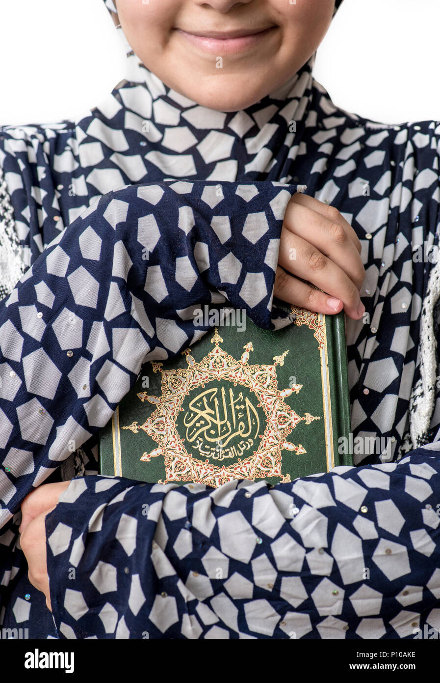 Joven chica musulmana abrazando Libro Sagrado del Corán Foto de stock