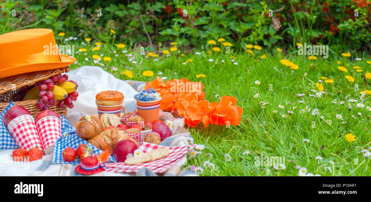en la celebración del día del rey. Almuerzo en el jardín. Cesta de frutas y pasteles. Gorro de color naranja. primavera en los Bajos. Tarjeta postal y texto
