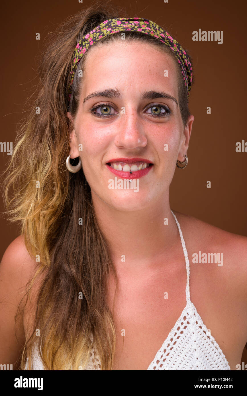 Hermosa joven mujer hispana contra el fondo marrón Foto de stock