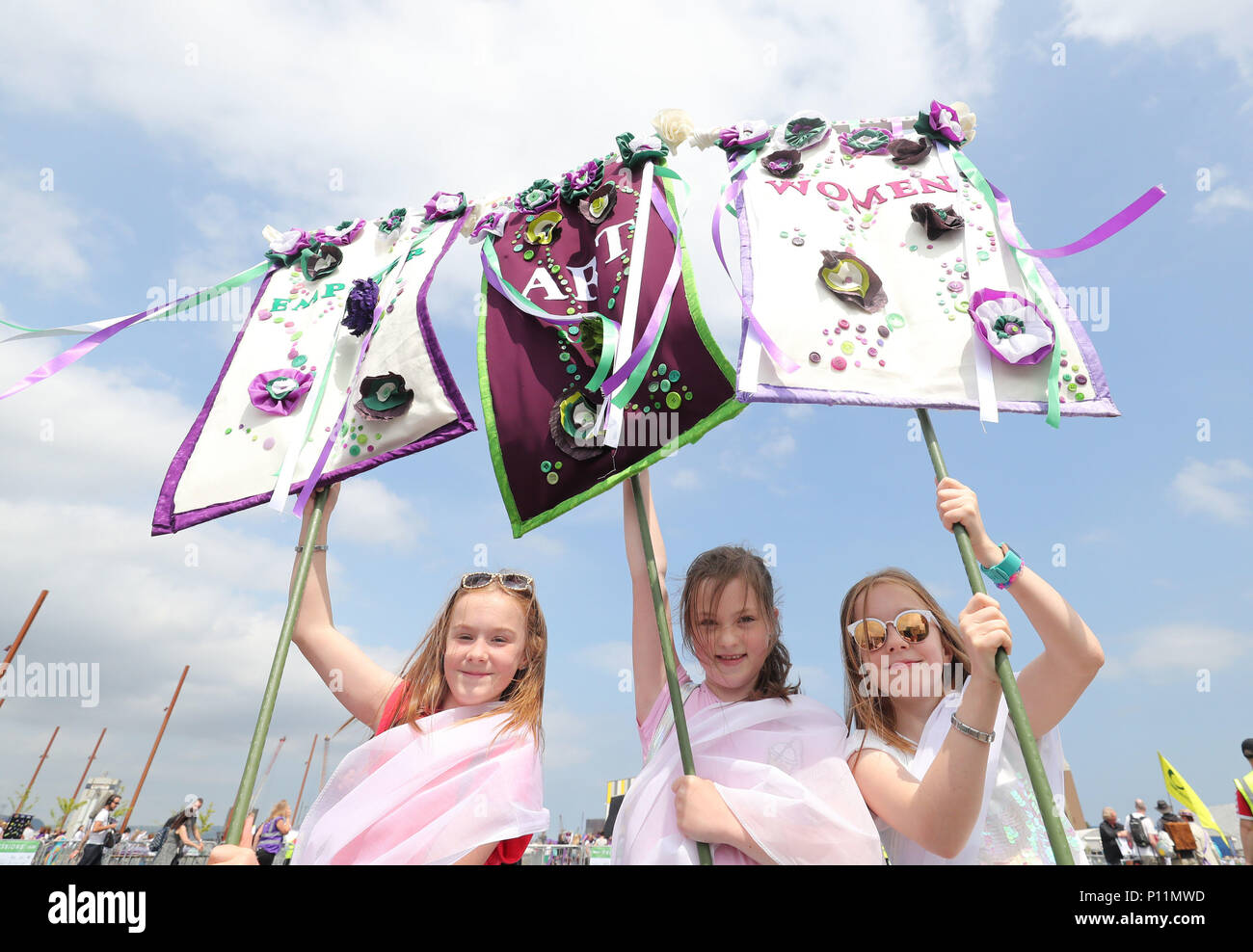 Las niñas con pancartas caseras participan en las procesiones' obras de marzo en Belfast, ya que marca los 100 años de la Ley de Representación del Pueblo que dio el primer británico a la mujer el derecho a votar y a presentarse a cargos públicos. Foto de stock