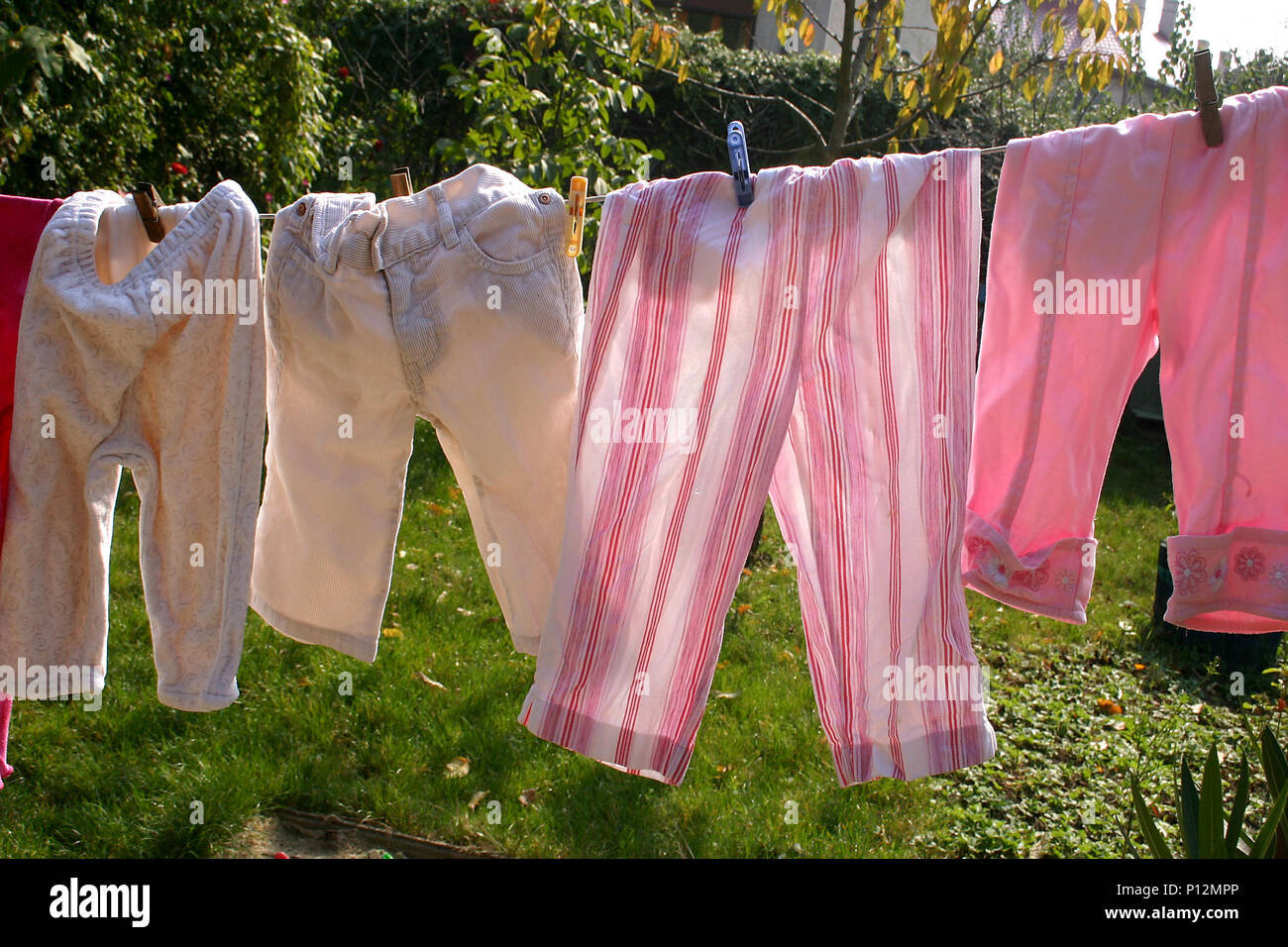 Ropa para bebés secándose al sol en la línea de la ropa Fotografía de stock  - Alamy