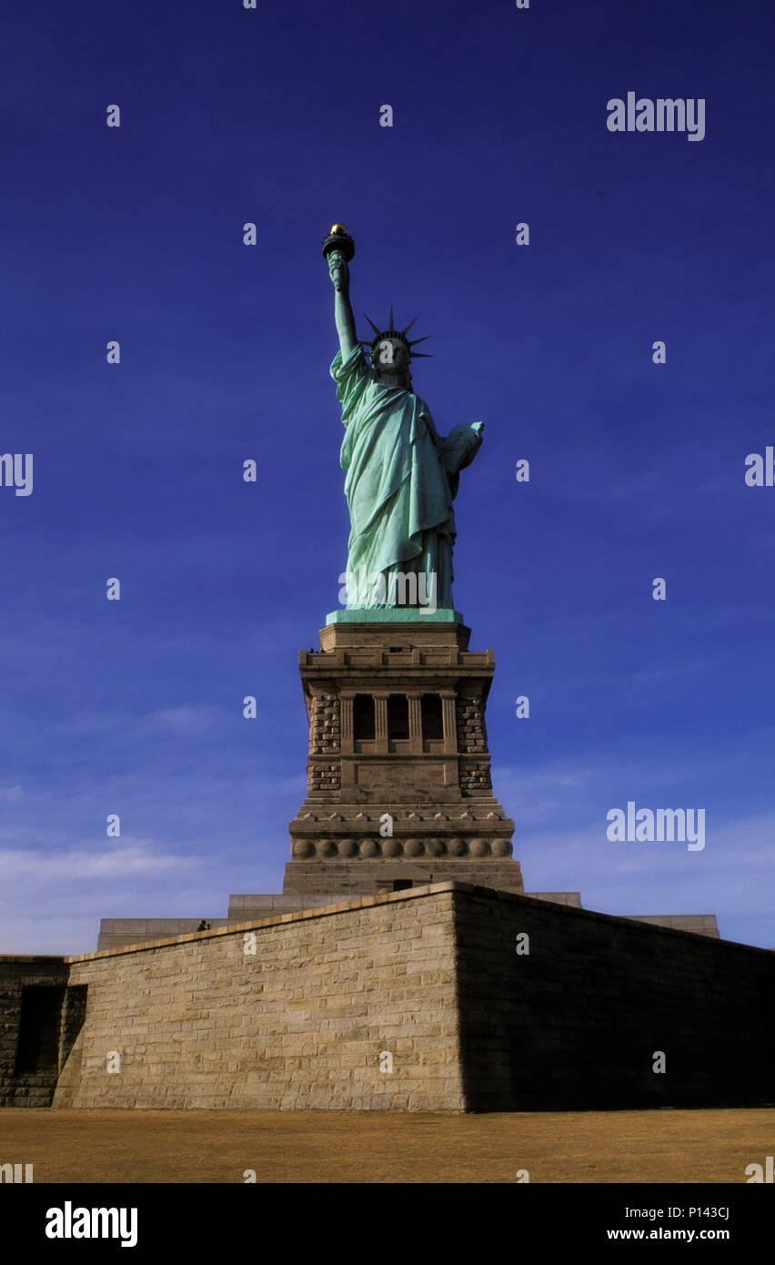 La estatua de la libertad, vista frontal del eje en la Isla de la libertad con fines de luz y sombra profunda, Nueva York, NY, EE.UU. Foto de stock