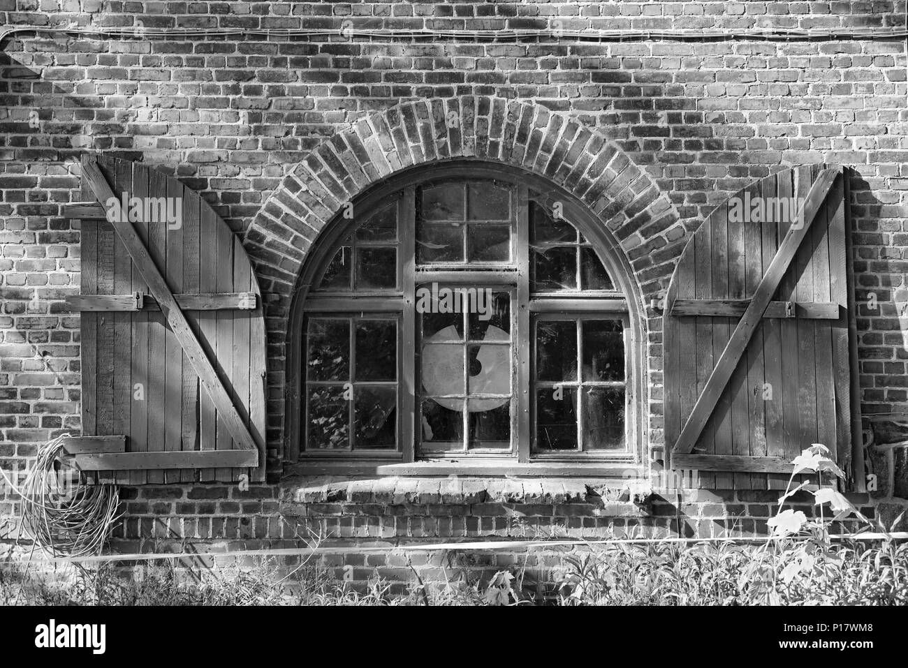 Una ventana en una granja de ladrillo, con persianas en blanco y negro, Schleswig Holstein, Alemania Foto de stock