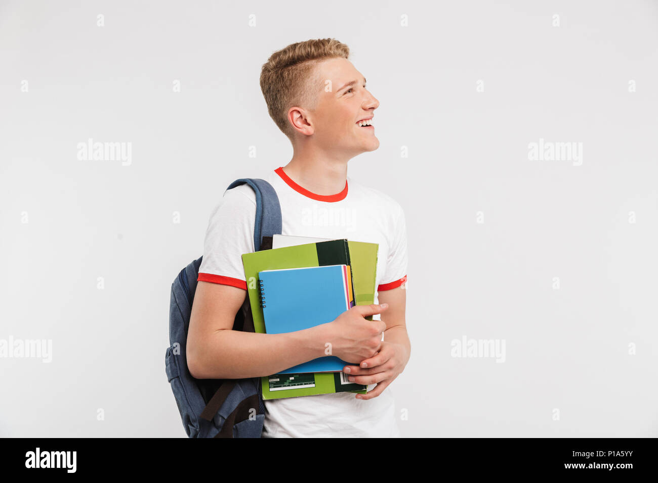 Imagen del hombre adolescente delgado universidad o colegio estudiante  llevando mochila mirando de lado al copyspace sujetando los libros de texto  más aislados backgr blanco Fotografía de stock - Alamy