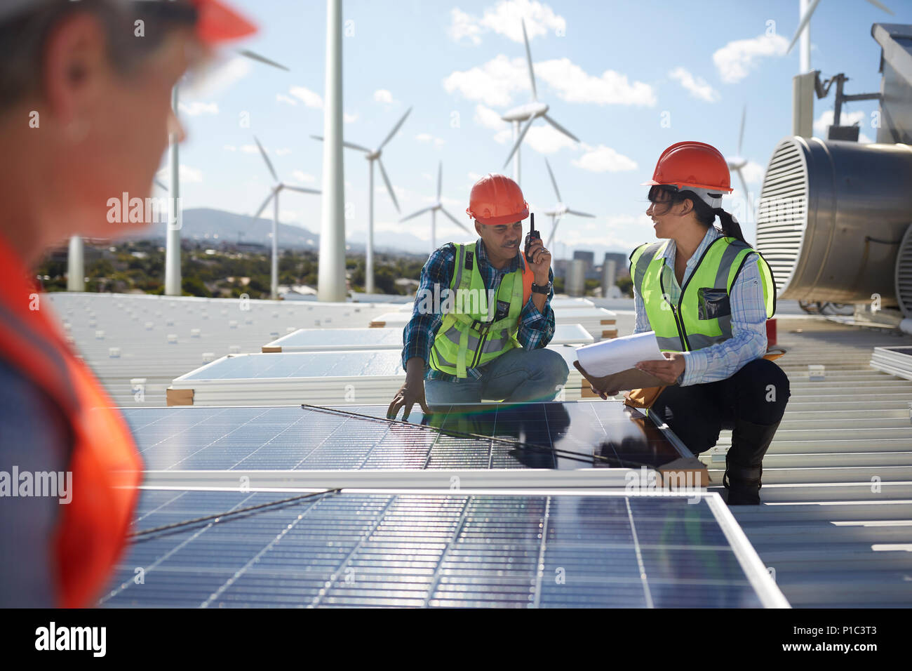 Ingenieros examinar los paneles solares en la planta de energía alternativa Foto de stock