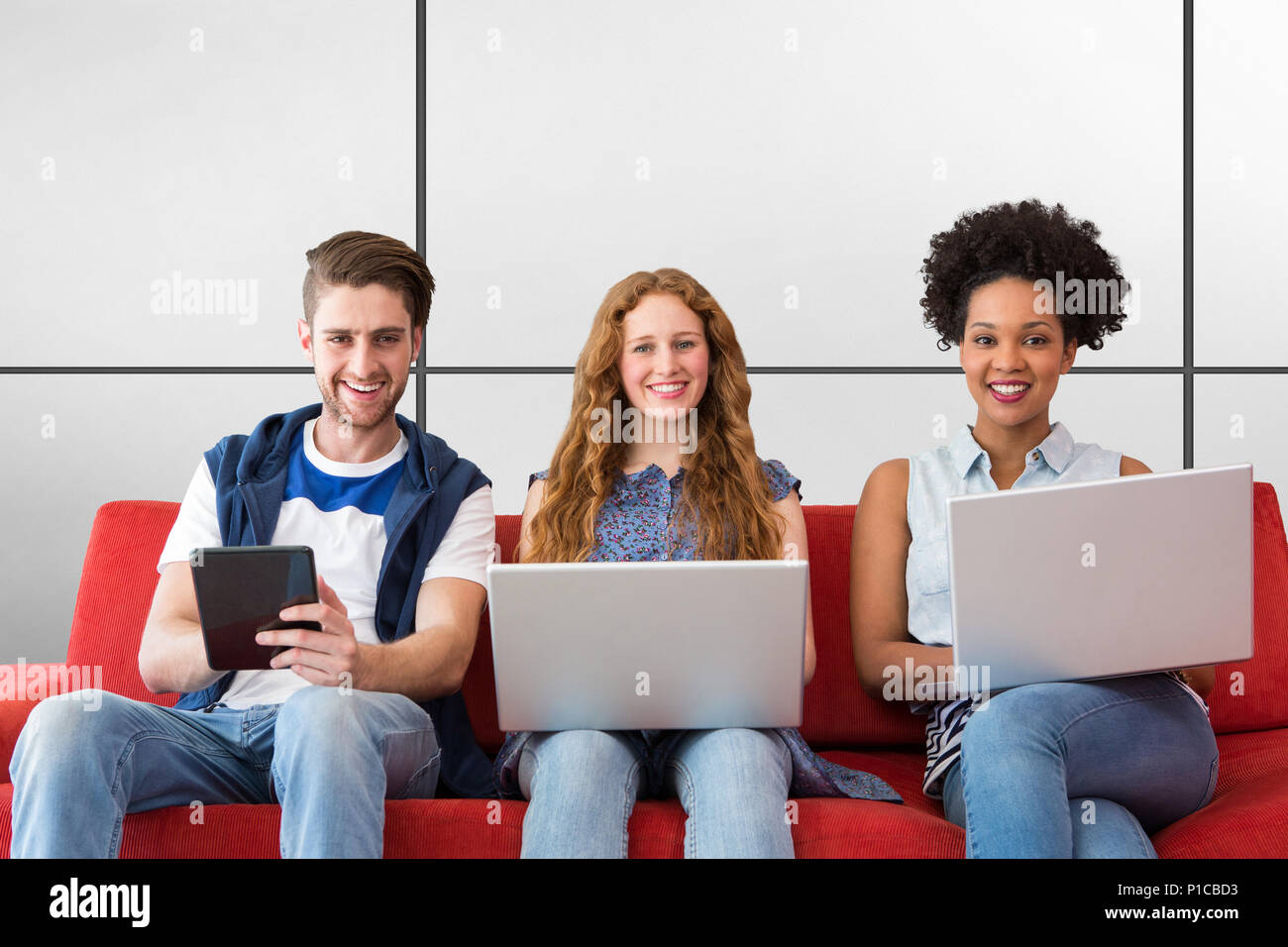 Imagen compuesta de jóvenes adultos mediante el uso de dispositivos electrónicos en el sofá Foto de stock