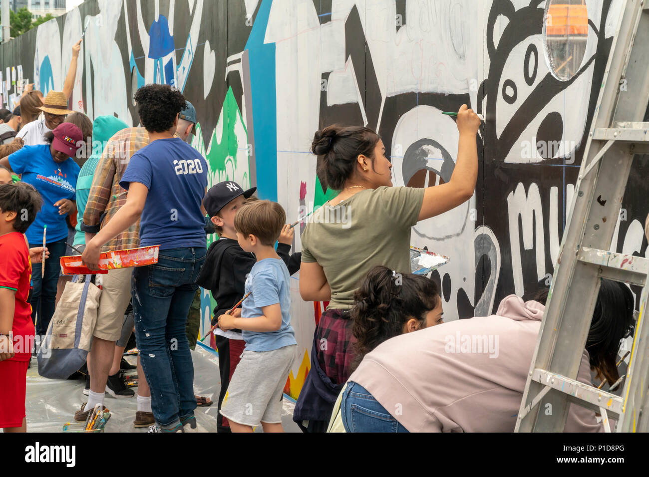Los visitantes pintar un mural sobre una pared de construcción adyacentes al  parque, durante la inauguración del Parque de Domino en el barrio de  Williamsburg de Brooklyn, en Nueva York, el domingo,