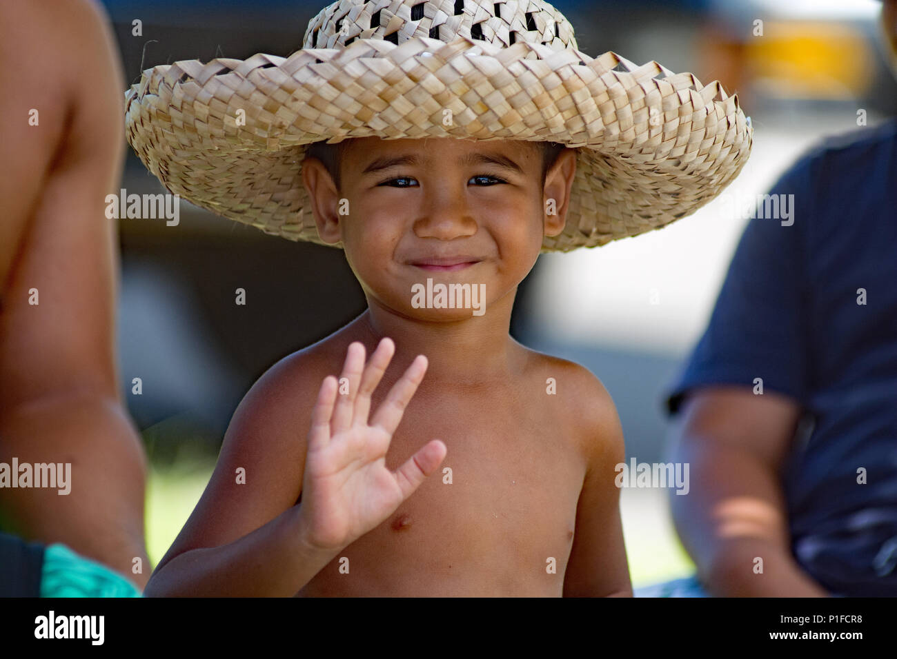 Chico lindo en hat agitando tejidas a mano. PAUL GAUGUIN CRUISE en Huahine Island Foto de stock
