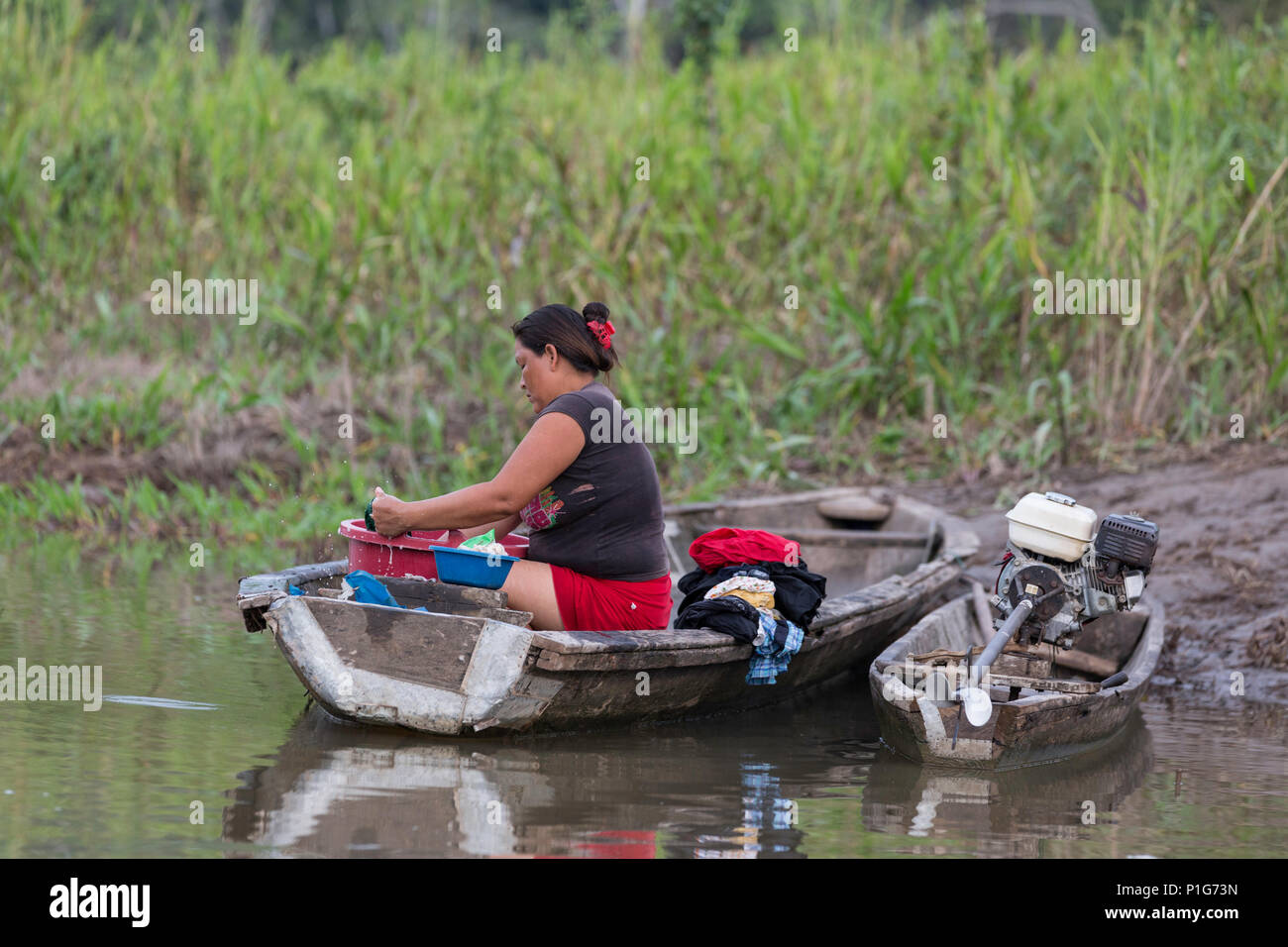 Mujer en la lavandería limpieza Atun Pozas, Superior de la cuenca del río Amazonas, Loreto, Perú Foto de stock