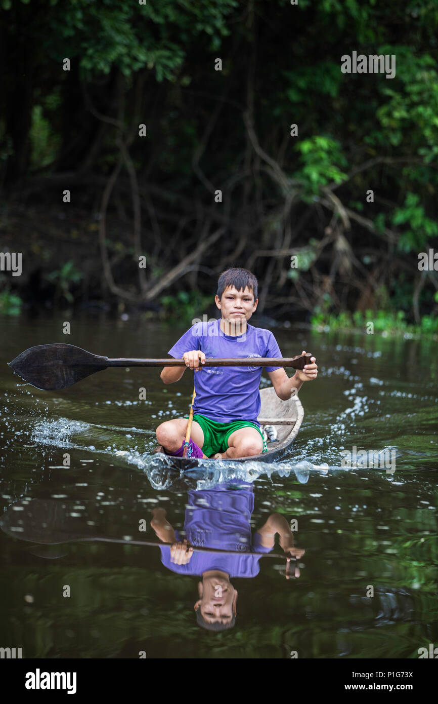 Joven en canoa en el Caño San Miguel, Superior de la cuenca del río Amazonas, Loreto, Perú Foto de stock